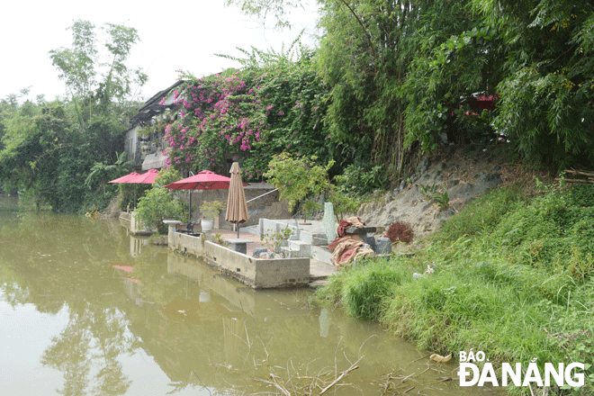 Một nhà dân cùng công trình xây dựng sát mép nước sông Túy Loan thuộc xã Hòa Phong, huyện Hòa Vang. Ảnh: HOÀNG HIỆP