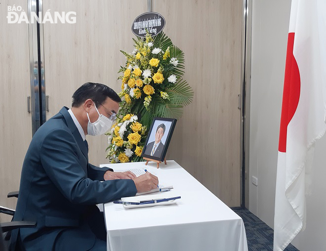 Chủ tịch UBND thành phố Lê Trung Chinh viết sổ tang tưởng niệm ngài Shizo Abe, cựu Thủ tướng Nhật Bản. Ảnh: L.P
