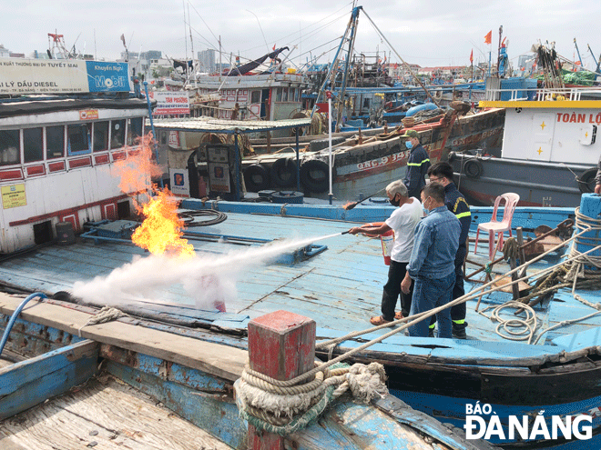 Police officers from the Da Nang Riverside Fire and Rescue Division conducting a fire drill on boats for fishermen. Photo: Ngoc Quoc