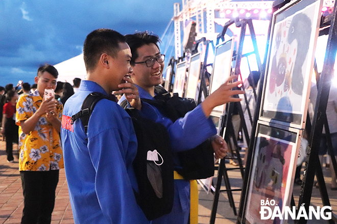 Người trẻ thích thú tham quan triển lãm tranh vẽ với chủ đề “Thế giới qua ánh mắt trẻ thơ Việt - Nhật”. Ảnh: XUÂN DŨNG