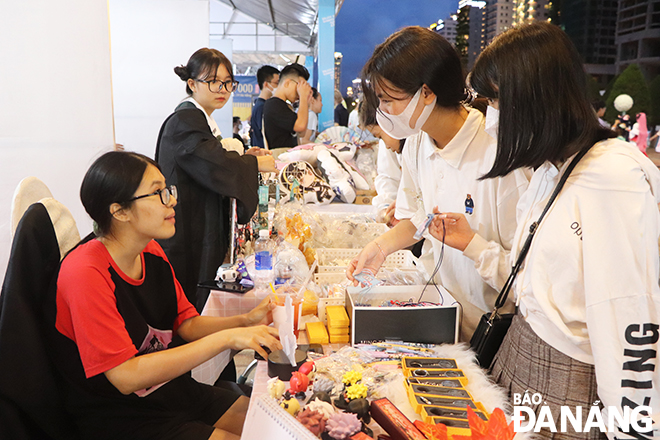 This year's festival also features more than 70 stalls in the fields of education, tourism, cuisine, and more. In the photo: Young people visit a Japanese souvenir stall. 