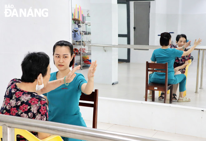 Bà Nguyễn Thị Hồng Minh cùng “múa” trước gương với kỹ thuật viên Hồ Thị Cẩm Linh.  Ảnh: NHƯ HẠNH