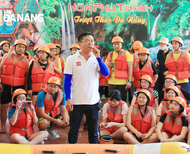 Hướng dẫn viên du lịch (giữa) đang thuyết trình điểm đến tại Khu du lịch Hòa Phú Thành, huyện Hòa Vang. Ảnh: Đ.H.L