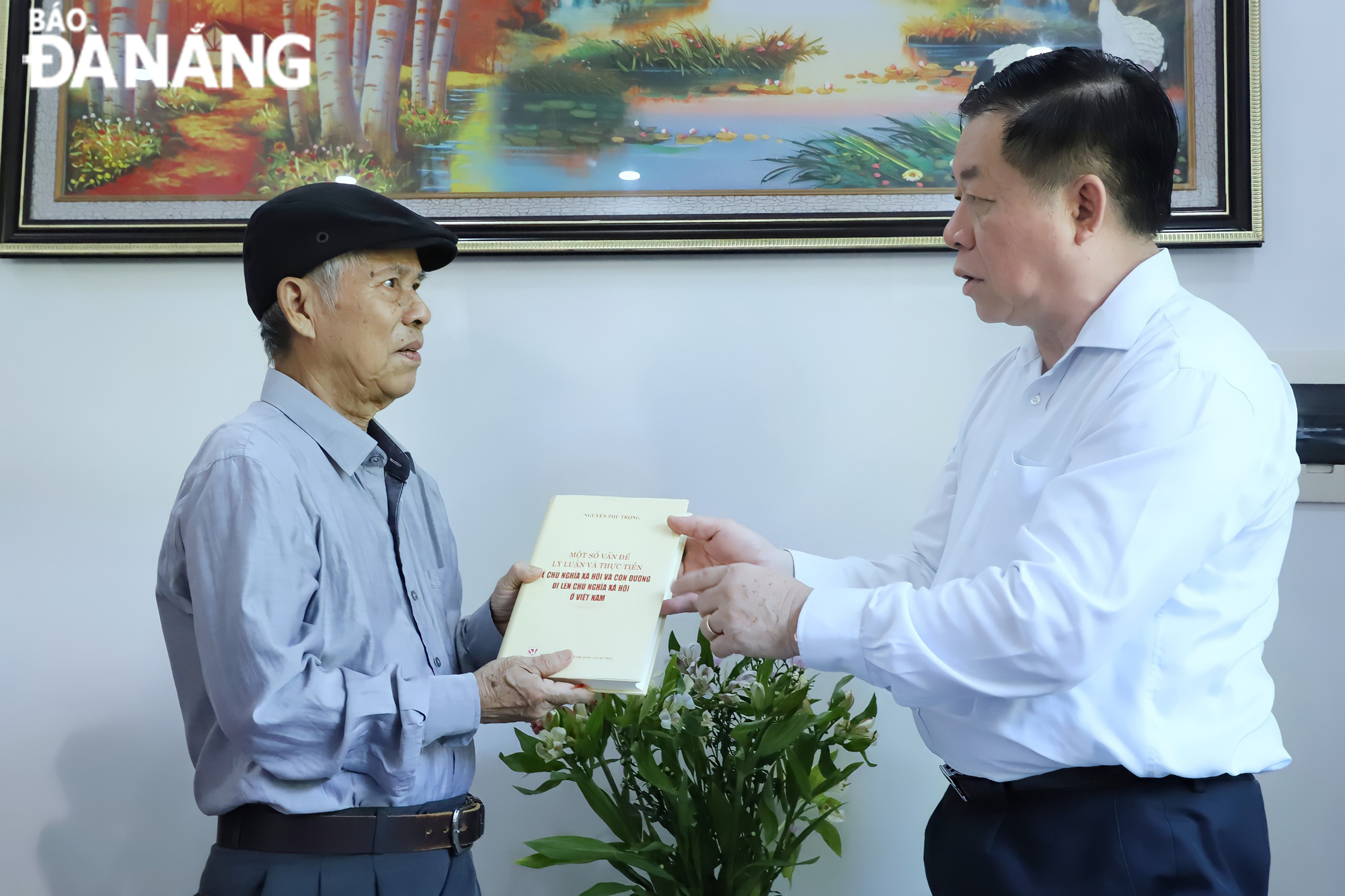 Head of the Party Central Committee’s Commission for Publicity and Education Nguyen Trong Nghia (right) presenting journalist Ho Duy Le a book titled ‘Some theoretical and practical issues on socialism and the path towards socialism in Viet Nam’ written by General Secretary Nguyen Phu Trong