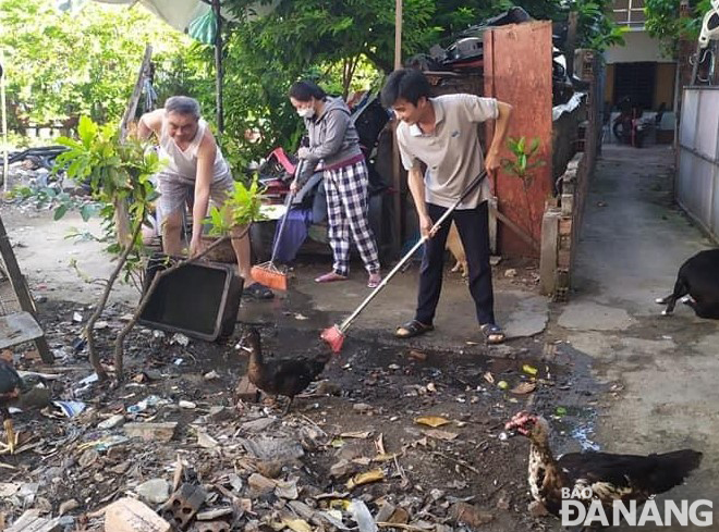 Người dân ở các kiệt, hẻm tại quận Hải Châu dọn vệ sinh, xử lý các điểm, vật dụng ứ đọng nước. 