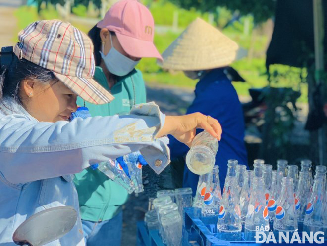 Người dân huyện Hòa Vang đổ bỏ nước trong các vỏ chai để diệt lăng quăng, bọ gậy.