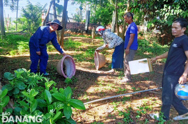 People in Hoa Vang District treat water containers to kill mosquito larvae.