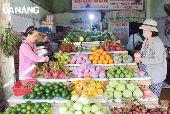 Từ sự hỗ trợ của các cấp chính quyền, chị Nguyễn Thị Hoài (bên trái) mở cửa hàng buôn bán trái cây mang lại thu nhập ổn định. Ảnh: P.N