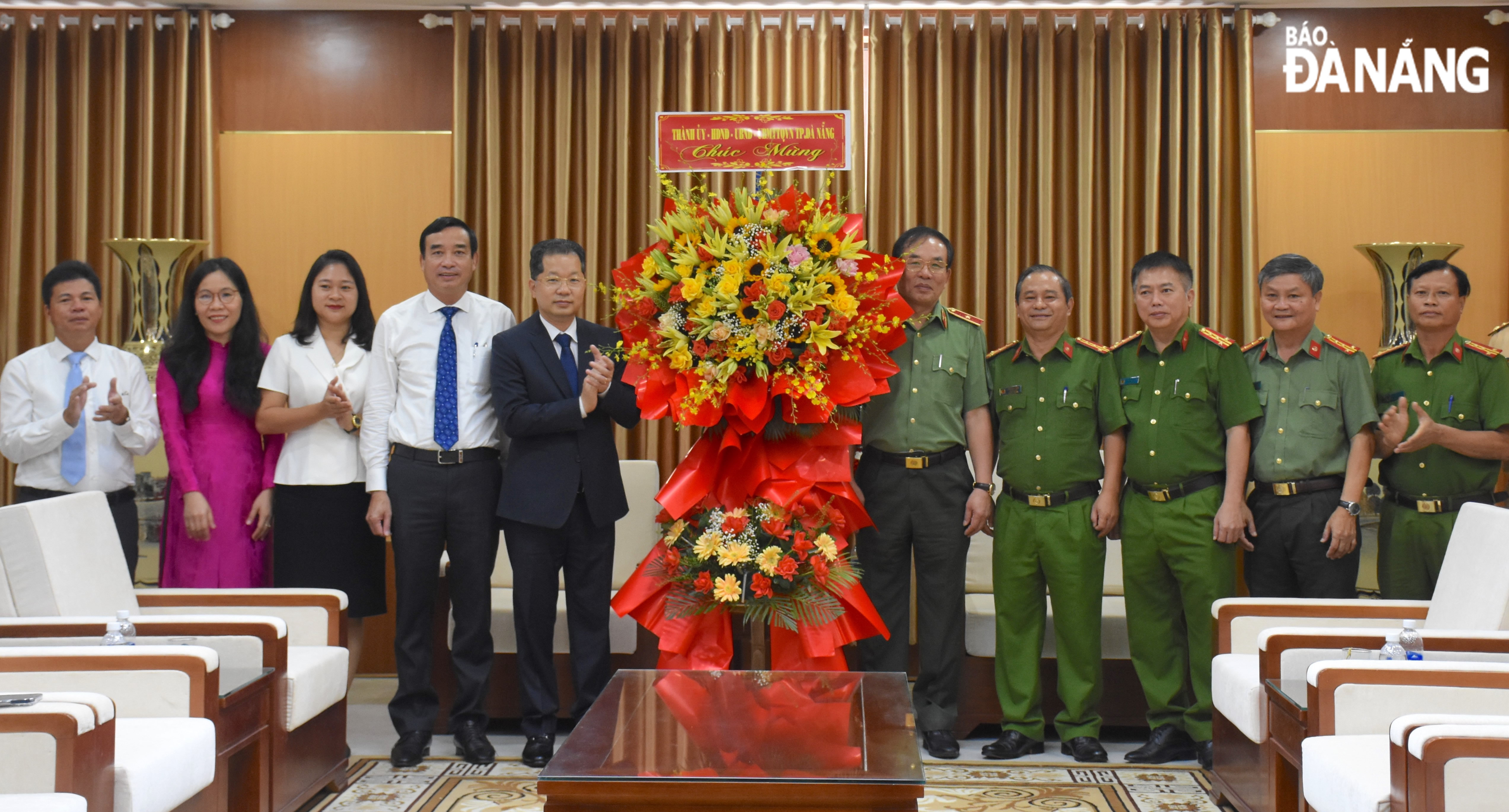 Bí thư Thành ủy Nguyễn Văn Quảng (thứ 5, trái sang) và Chủ tịch UBND thành phố Lê Trung Chinh (thứ 4, trái sang) tặng hoa chúc mừng Công an thành phố. Ảnh: LÊ HÙNG