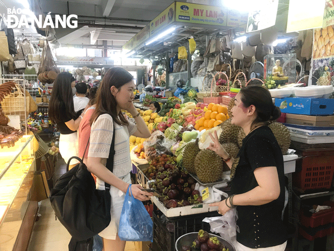 Hoạt động dịch vụ khởi sắc, góp phần phát triển kinh tế - xã hội trên địa bàn quận Hải Châu. Trong ảnh: Du khách mua sắm tại chợ Hàn. Ảnh: M.Q	