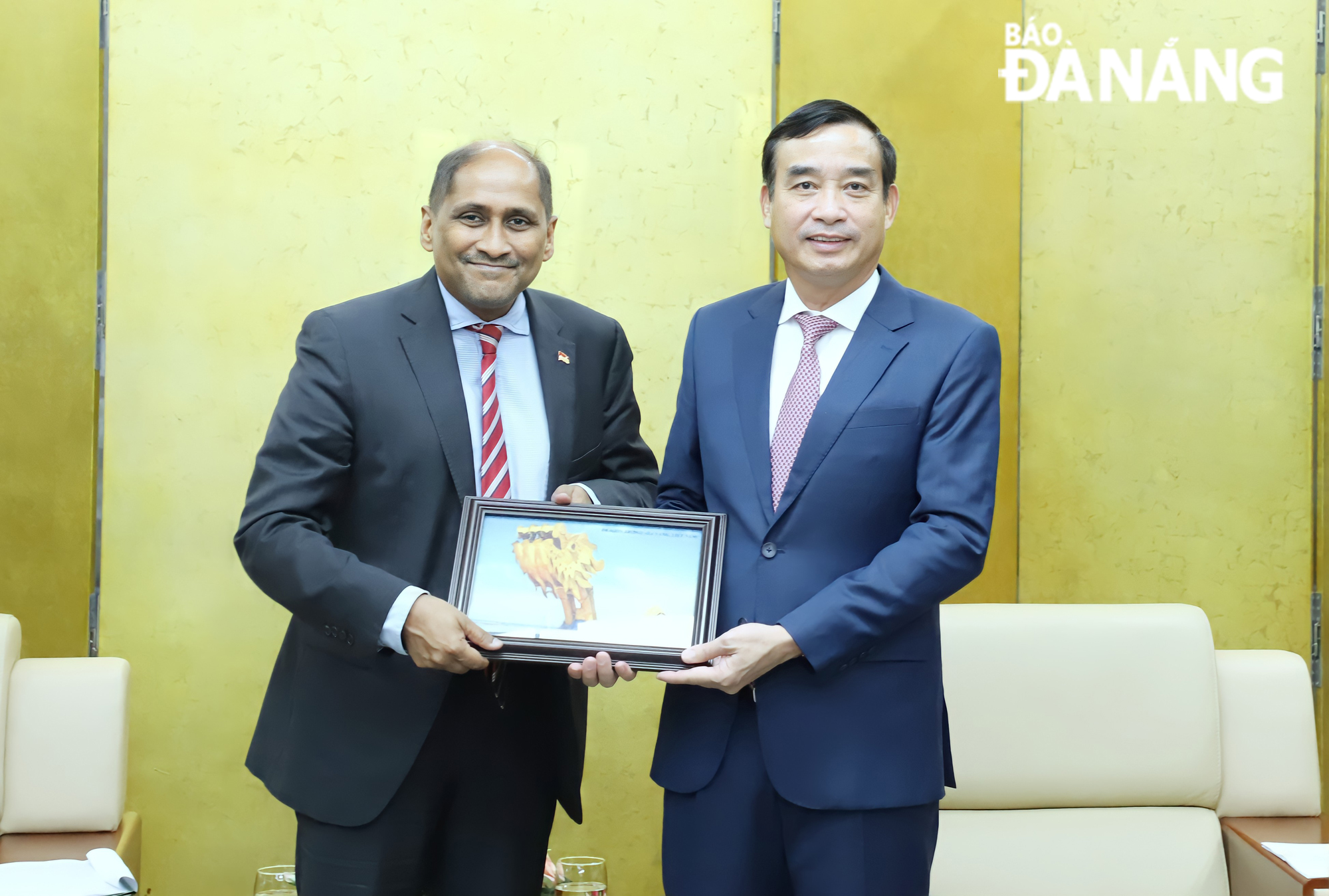 Da Nang Peoples Committee Chairman Le Trung Chinh (right) presenting a presenting a momento the Singapore diplomat. Photo: NGOC PHU