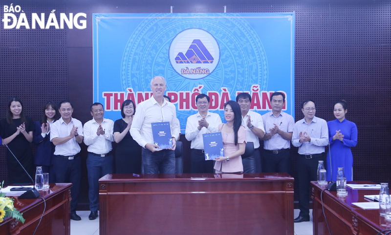 Phó Chủ tịch UBND thành phố Trần Phước Sơn (thứ 6 từ phải sang) cùng đại diện các sở, ban, ngành chứng kiến các đơn vị ký kết biên bản ghi nhớ. Ảnh: THU HÀ.