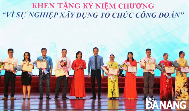 Chủ tịch Liên đoàn Lao động thành phố Nguyễn Duy Minh (giữa) tặng Kỷ niệm chương “Vì sự nghiệp xây dựng tổ chức Công đoàn” cho các cá nhân là lãnh đạo đơn vị, cán bộ Công đoàn có nhiều thành tích xuất sắc. Ảnh: X.H	