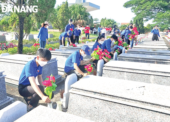 Đoàn viên, thanh niên huyện Hòa Vang thay mới hàng trăm bó hoa sen, lọ hoa tại Nghĩa trang liệt sĩ thành phố (xã Hòa Khương). Ảnh: NGỌC QUỐC