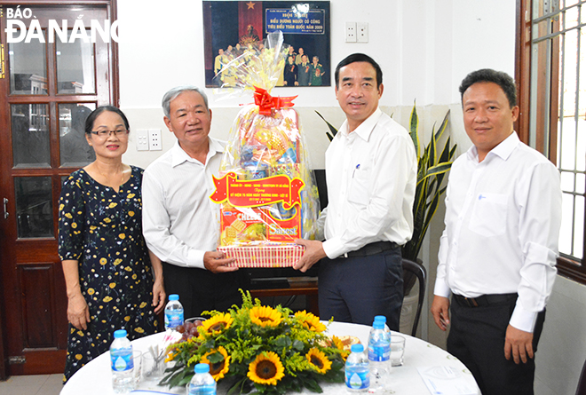 Da Nang People's Committee Chairman Le Trung Chinh (second, right) presenting a gift to the family of war invalid Lam Van Ba