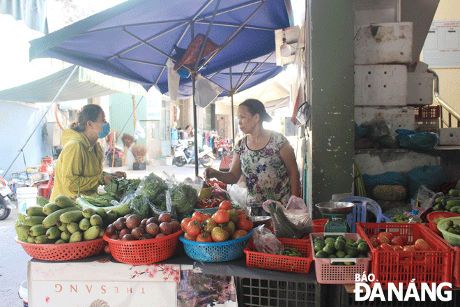 Ho Thi Dieu Oanh and her La Huong vegetable stall at Nam Duong market. Photo: HUYNG TRANG