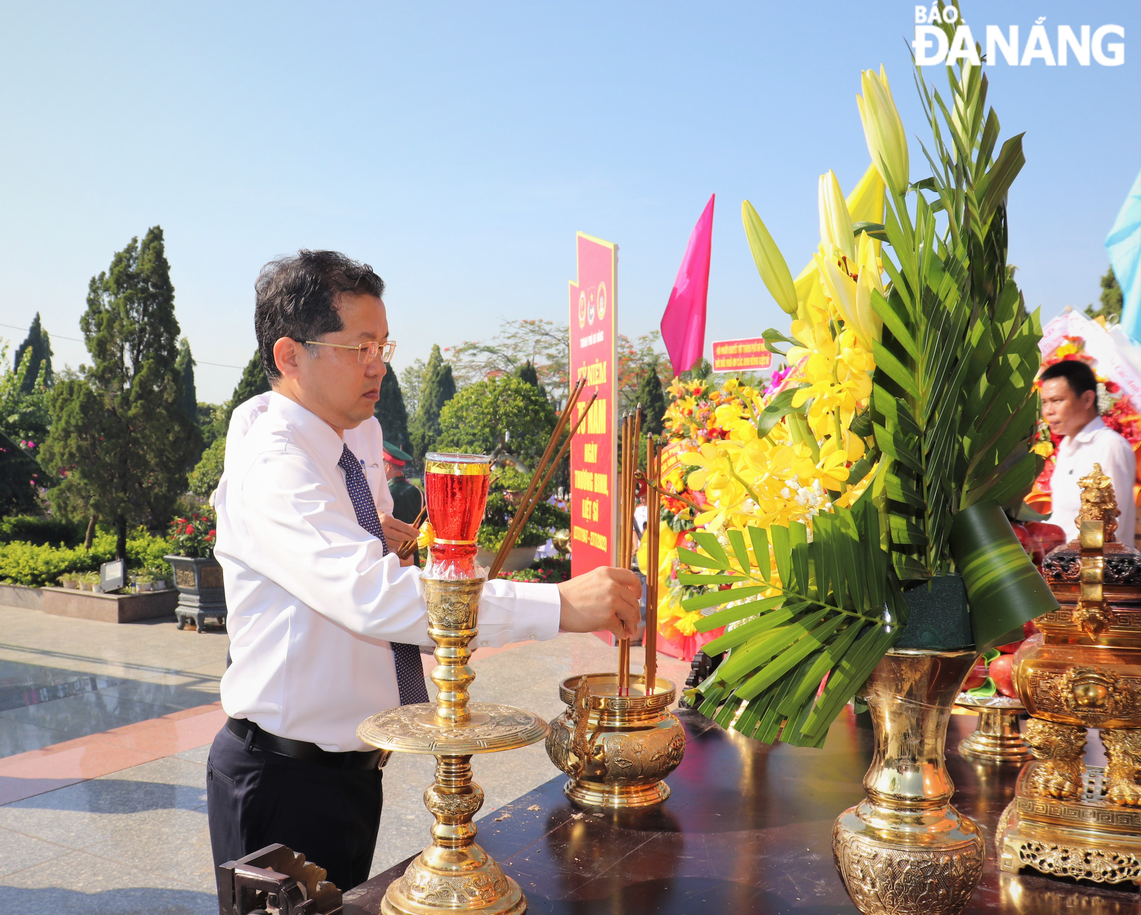 Mr Nguyen Van Quang burning incense at the citys Martyrs Cemetery. Photo: LE HUNG