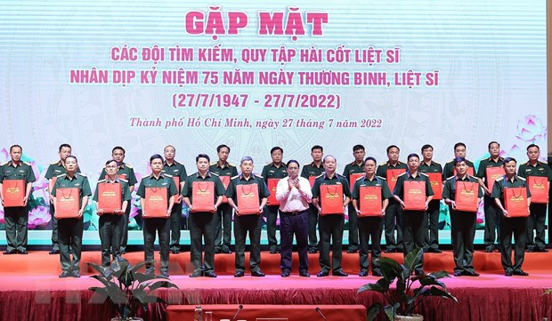 Thủ tướng Phạm Minh Chính tặng quà cho đại diện các đội tìm kiếm, quy tập hài cốt liệt sỹ. (Ảnh: Dương Giang/TTXVN)