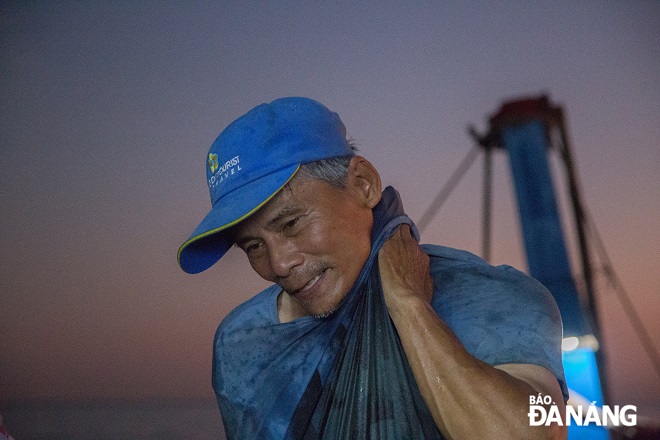 The man wiping sweat on his face with his T-shirt after hours of pulling the fishing net