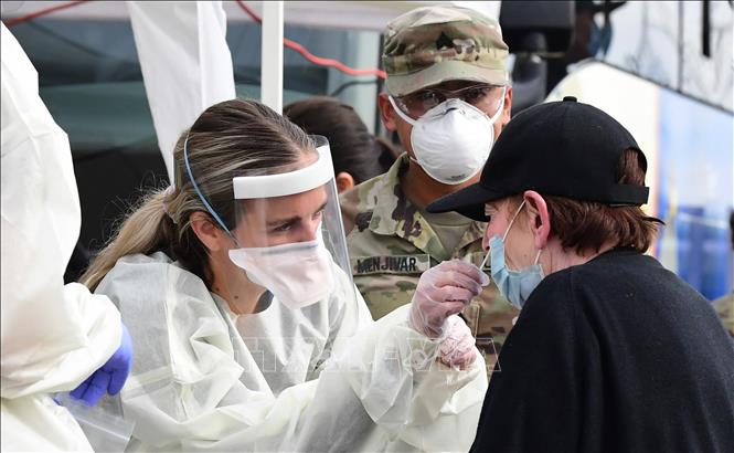 Nhân viên y tế lấy mẫu xét nghiệm COVID-19 cho người dân tại California, Mỹ. Ảnh: AFP/TTXVN