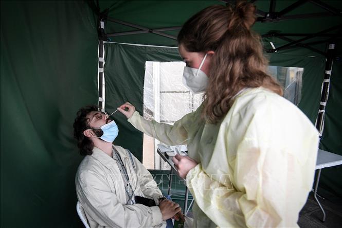 Nhân viên y tế lấy mẫu xét nghiệm COVID-19 cho người dân tại Paris, Pháp, ngày 6/7/2022. Ảnh: AFP/ TTXVN