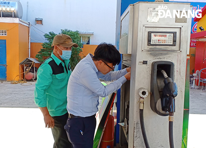 An expert from the Office of Standards, Metrology and Quality Management under the Da Nang Department of Science and Technology checks a petrol metering pole at a petrol station on Ton Duc Thang Street, Lien Chieu District, Da Nang. Photo: M.Q