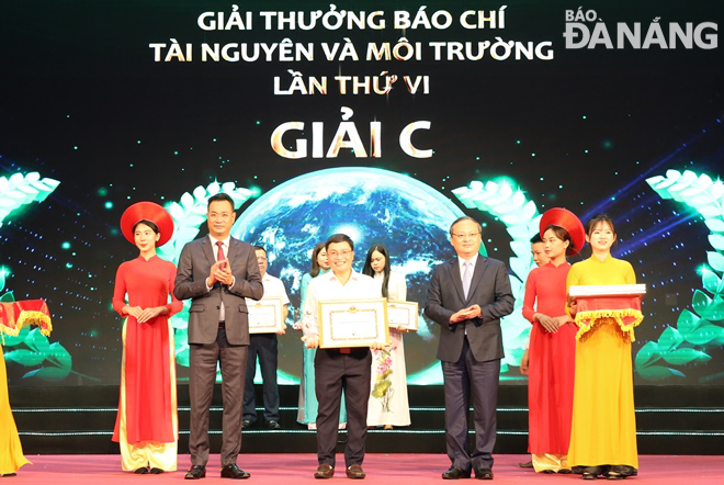 Tổng Giám đốc Đài Truyền hình Việt Nam Lê Ngọc Quang (thứ 2 từ trái sang) và Tổng Giám đốc Đài Tiếng nói Việt Nam Đỗ Tiến Sỹ (thứ 3 từ phải sang) trao giải C, Giải thưởng Báo chí tài nguyên và môi trường lần thứ VI cho đại diện nhóm tác giả Hứa Văn Hải - Lê Hoàng Hiệp của Báo Đà Nẵng. Ảnh: NAM TRÂN