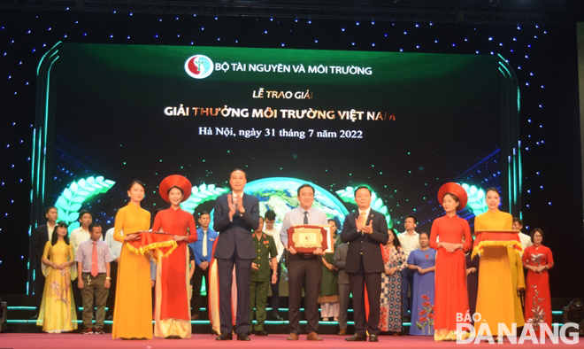 Minister of Natural Resources and Environment Tran Hong Ha (3rd, right) and Vice Chairman of the Central Committee of the Viet Nam Fatherland Front Phung Khanh Tai (3rd, left) presents the Viet Nam Environment Award for the leader of the Environmental Protection Sub-Department under the Da Nang Department of Natural Resources and the Environment. Photo: DNO