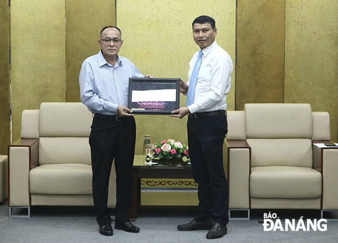 Phó Chủ tịch Thường trực UBND thành phố Hồ Kỳ Minh (bên phải) tặng quà lưu niệm cho Phó tỉnh trưởng Champasak (Lào) Somboun Haeungvongsa. Ảnh: N.QUANG	