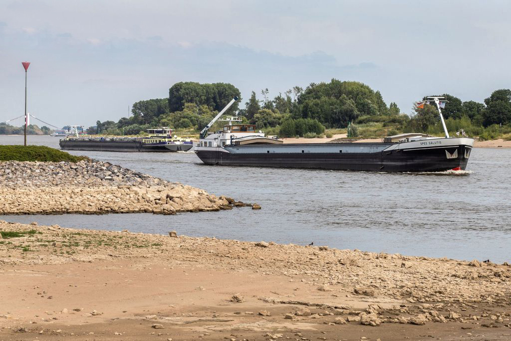 Những chiếc sà lan di chuyển trên mực nước thấp do hạn hán trên sông Rhine ở Lobith (Hà Lan) vào ngày 30-7-2022. Ảnh: Bloomberg