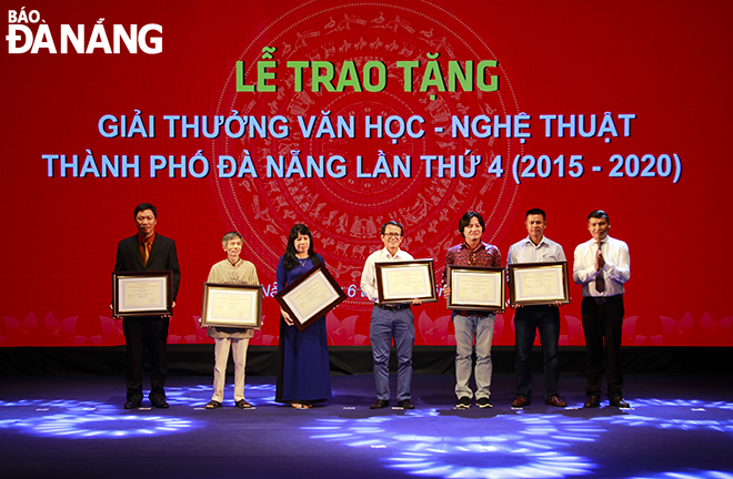 Phó Chủ tịch Thường trực UBND thành phố Hồ Kỳ Minh (bìa phải) trao giải A cho các tác giả có tác phẩm xuất sắc. Ảnh: XUÂN DŨNG
