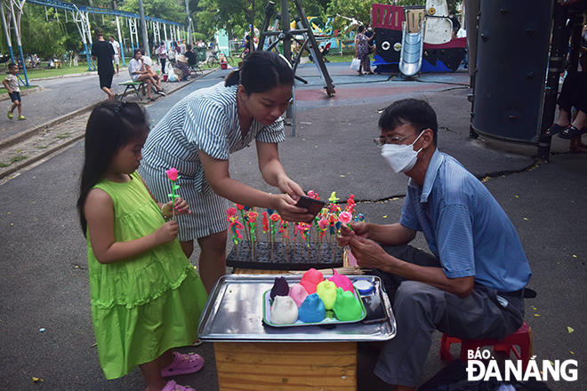 Mrs. Nguyen Thi Phuong Thuy (in striped shirt) is inviting artisan Kinh to perform the shaping of 'to he' at her kindergarten.