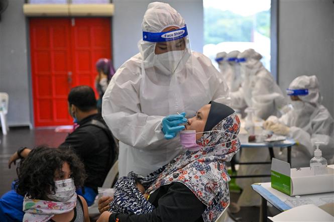 Nhân viên y tế lấy mẫu xét nghiệm Covid-19 cho người dân tại Kuala Lumpur, Malaysia. Ảnh: AFP/TTXVN