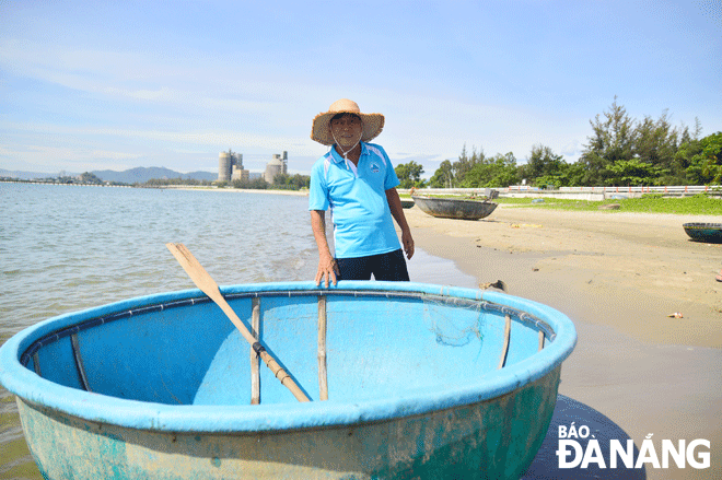 Ngư dân Nguyễn Quang bên chiếc thuyền thúng gắn liền với nghề biển. Ảnh: X.S