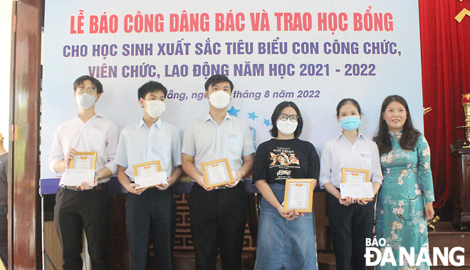 Chủ tịch Công đoàn Viên chức thành phố Nguyễn Thị Dung (bên phải) trao học bổng cho các em đạt thành tích cao trong học tập. Ảnh: X.HẬU