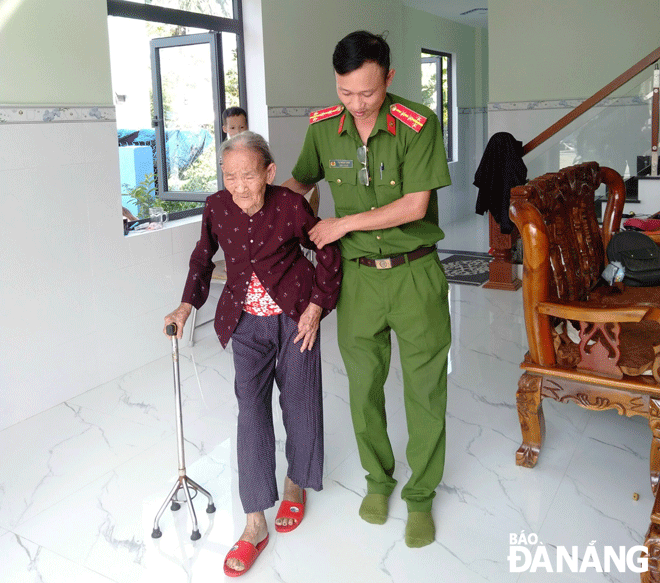 Đại úy Tạ Ngọc Anh giúp người cao tuổi tại địa phương đến trụ sở Công an xã Hòa Sơn làm căn cước công dân. Ảnh: C.A