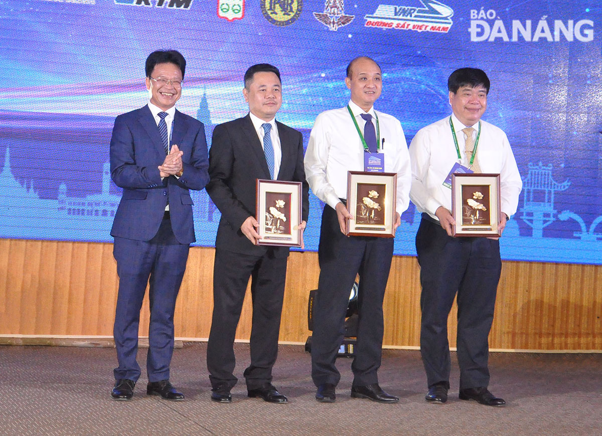 Phó Chủ tịch UBND thành phố Lê Quang Nam (thứ 2 từ phải sang) nhận quà lưu niệm của Ban tổ chức. Ảnh: THÀNH LÂN