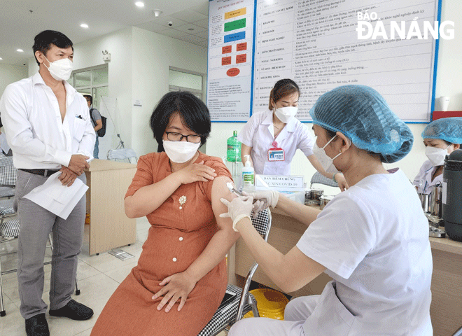 Tiêm vắc-xin cho nhân viên y tế tại Trung tâm Kiểm soát bệnh tật thành phố ngày 24-8.  Ảnh: PHAN CHUNG