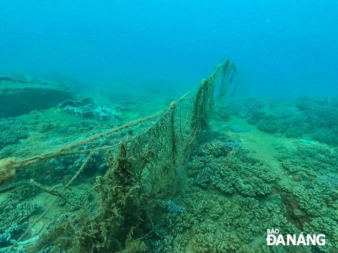 Pieces of fishing nets lying on the coral reefs of the Man Thai seabed are gradually removed by Mr. Trung and his diving team.