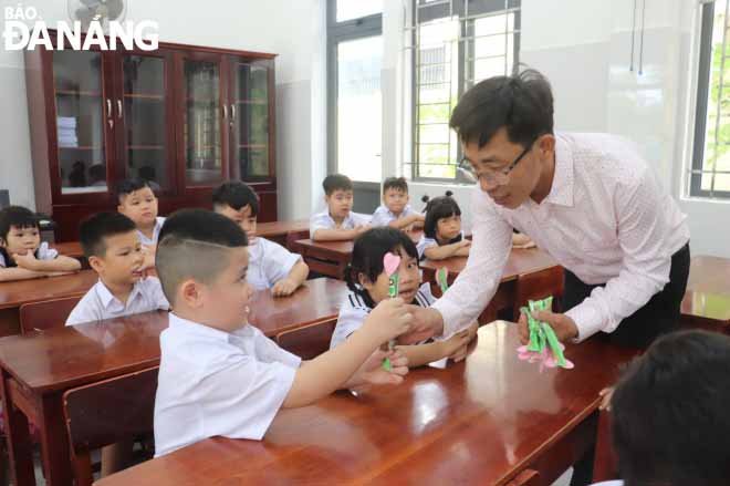 Thầy Hiệu trưởng phát quà là những chiếc kẹo xinh để động viên các em. Ảnh chụp tại Trường Tiểu học Võ Thị Sáu (quận Hải Châu). NGỌC HÀ
