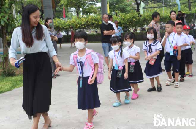 A teacher taking her new pupils to the classroom. Photo taken at the Ly Tu Trong Primary School.