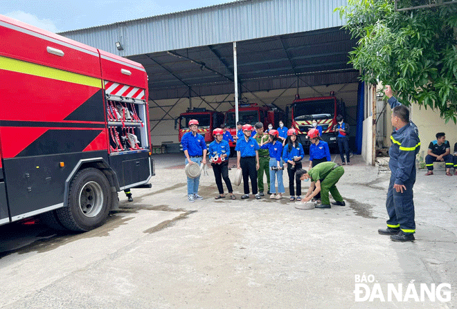 Pupils and students in Hoa Cuong Nam Ward are instructed to use fire fighting equipmen by youth union members of the Fire Prevention and Fighting and Rescue Police Division. Photo: HOANG HIEP