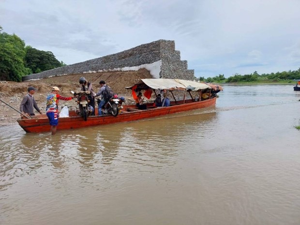 Residents with their motorcycles ride on a banca as they cross a submerged bridge due to a swollen river in Cauayan city, Isabela province, north of Manila on August 24, 2022, a day after Tropical storm Ma-on barreled the province. (Photo: AFP)