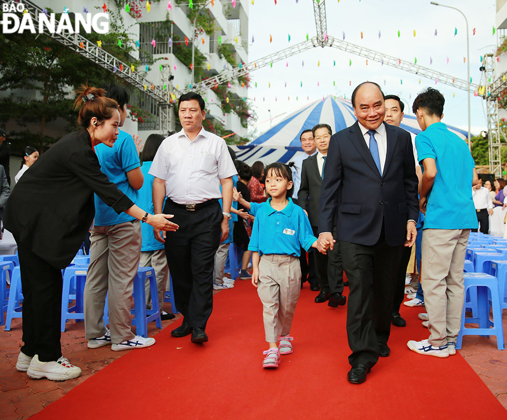 President Nguyen Xuan Phuc and leaders of national ministries welcome students whose parents have died due to COVID and are now able to go to school to start their first school year. Photo: TRIEU TUNG