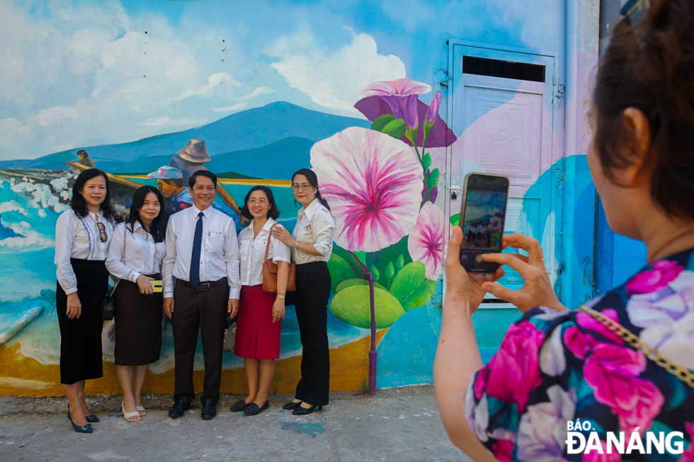 People excitedly took souvenir photos with the new frescoed road by the beach of Da Nang. Photo: X.D