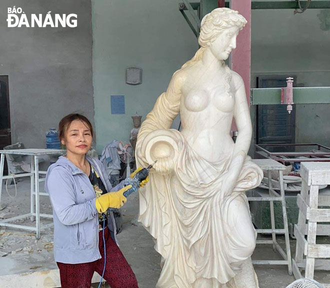 Ms Le Thi Hoa Binh and one of her artworks. Photo: HONG QUANG