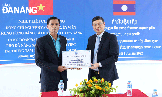 Phó Chủ tịch Thường trực UBND thành phố Hồ Kỳ Minh (bên phải) trao tặng quà cho Trung tâm tiếng Việt tỉnh Sê Kông.Ảnh: Ngọc Phú