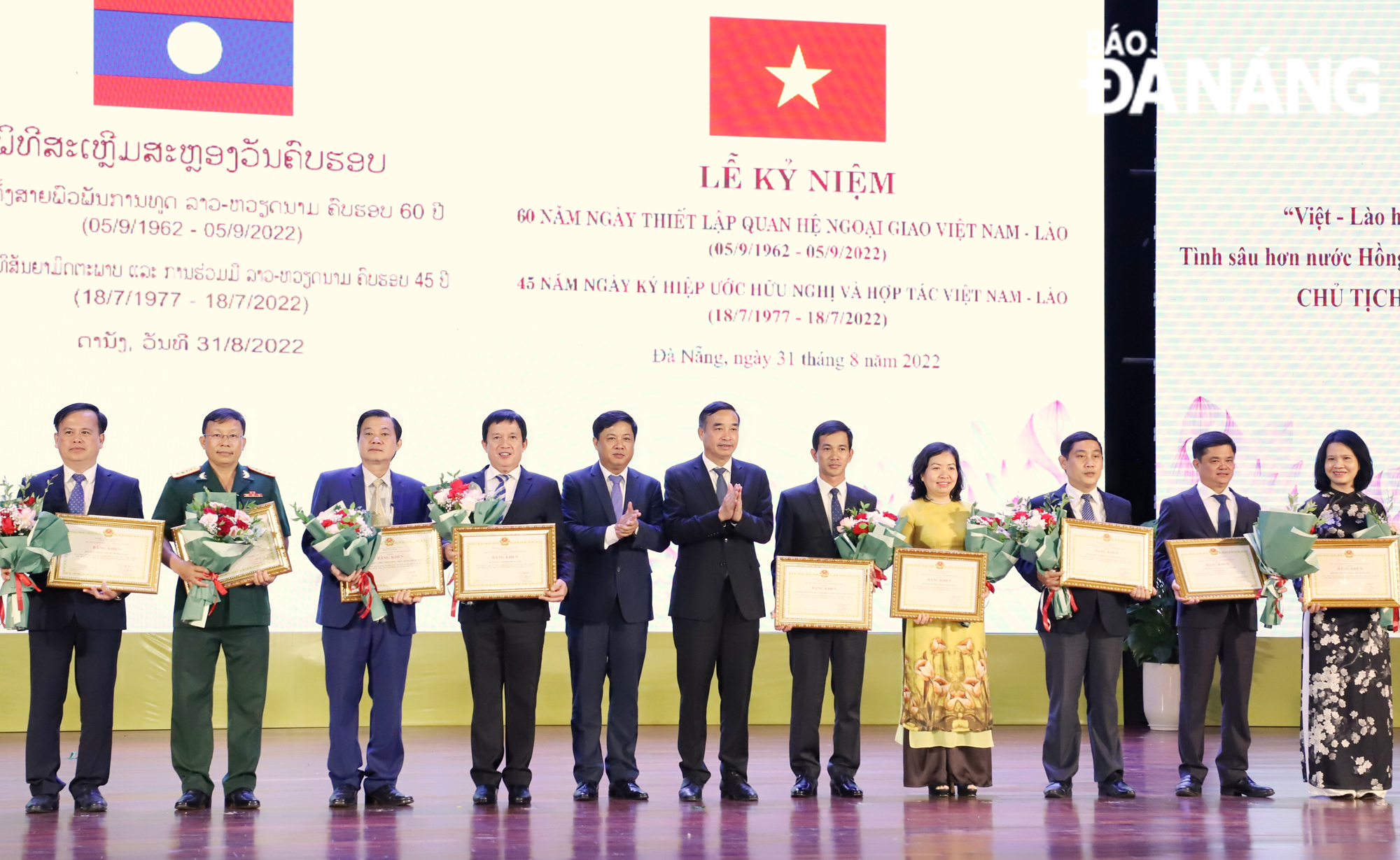 Municipal Party Committee Deputy Secretary Luong Nguyen Minh Triet and Chairman of the municipal People's Committee Le Trung Chinh awarding Certificates of Merit to outstanding collectives and individuals in recognition of their active involvement in strengthening friendship and cooperation relations between Da Nang and Lao localities during the 2018- 2022 period.