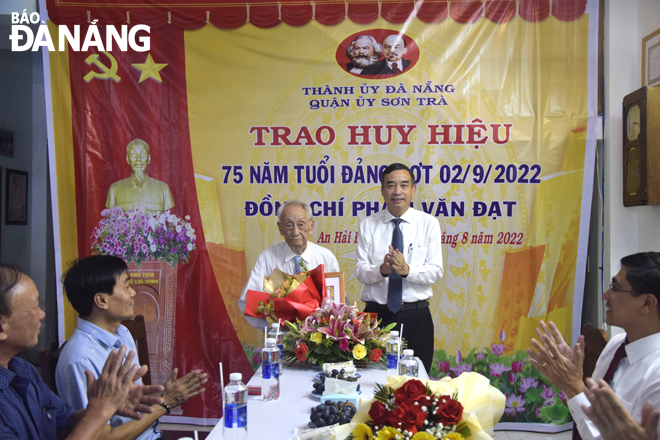 Chủ tịch UBND thành phố Lê Trung Chinh đến nhà và trao Huy hiệu 75 năm tuổi Đảng cho đảng viên Phạm Văn Đạt. Ảnh: T. HUY