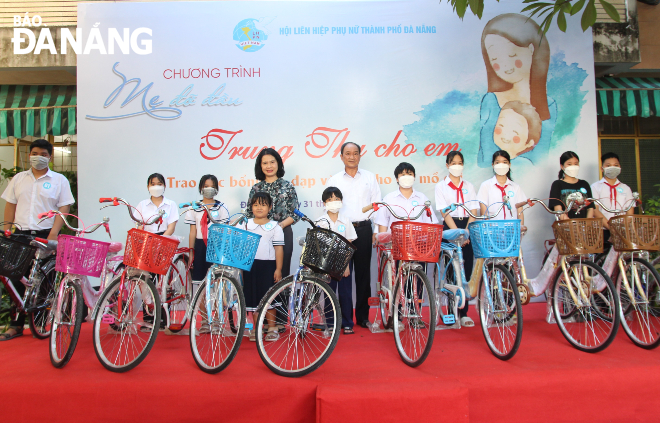 Representatives of the event’s organisers present 10 bicycles to orphaned students with difficult circumstances. Photo: NGOC QUOC